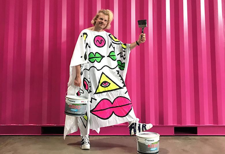 Kuvassa on Teemu Keisteri päällään kaapu, jossa on sarjakuvamaisia kuvia valkoisessa kaavussa.