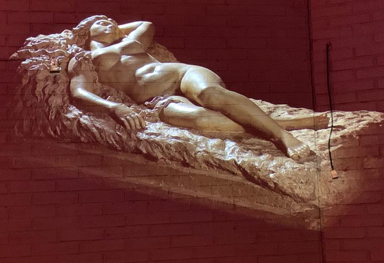 Kuvassa on digitoitu Kalevalan Kyllikki makaavana patsaana jalustan päällä.