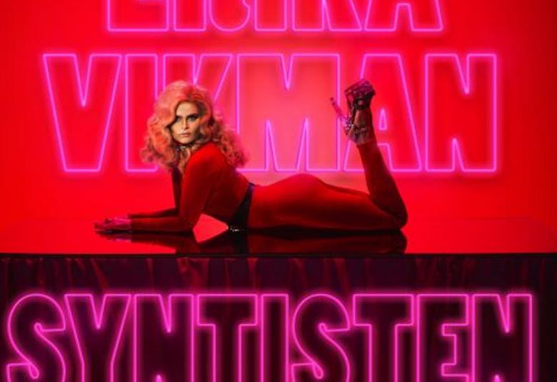 Kuvassa on Erika Vikman vatsallaan tason päällä ja kuva on väriltään punainen.  Taustalla on Erikan nimi ja alla levyn Syntisten pöytä nimi.