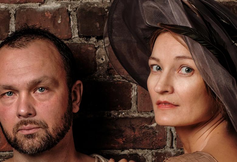 Kuvassa ovat Jari Virman ja Matleena Kuusniemi, jolla on iso musta hattu päässään. Kuva on kasvokuva molemmista.