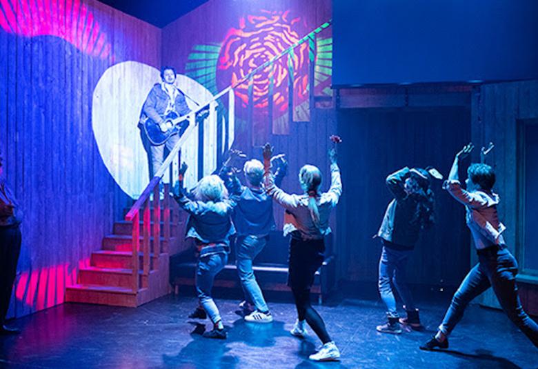 Kuvassa on Sebastian seisomassa portaiden yläpäässä ja alhaalla seisoo nuoria faneja katsomassa Sebastiania.  Kuvan sävy on sininen.