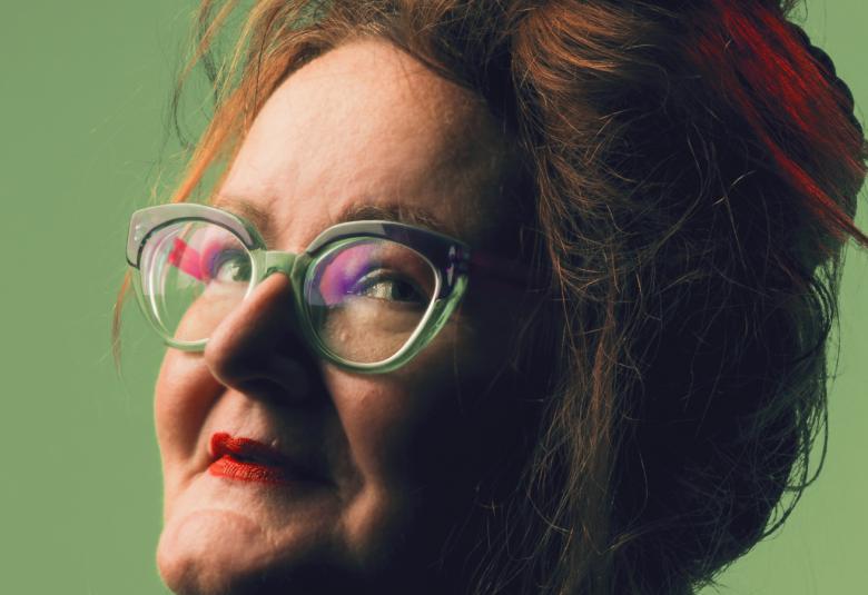 Kuvassa on Ann-Stina Nykäsen kasvot sivuttain kuvattuna. Hänellä on silmäläsit ja tukka nutturalla ylöspäin.