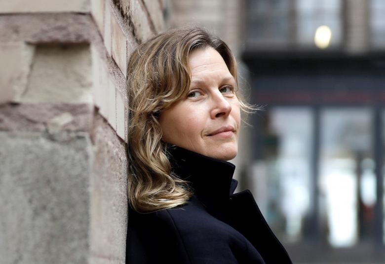 Kuvassa on Niki Matheson seisomassa sivuttain nojaten seinään.