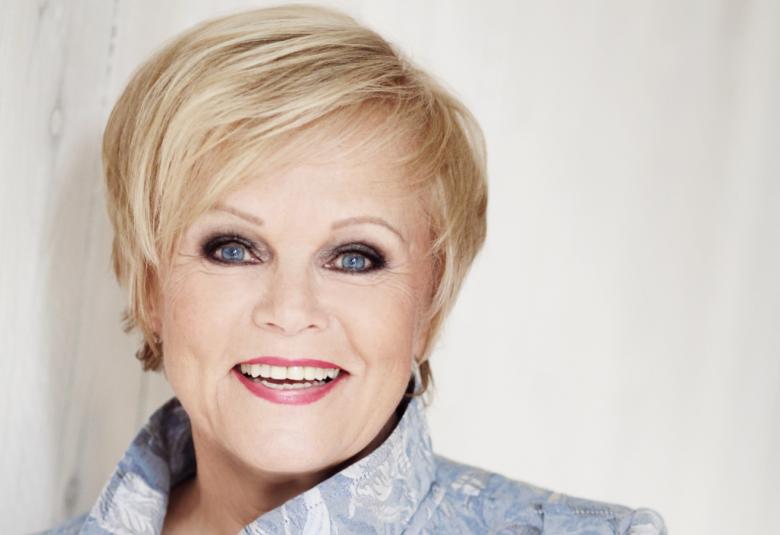 Kuvassa on Katri Helenan kasvot ja hiukan vaaleita kohollaan olevia kauluksia jakusta.