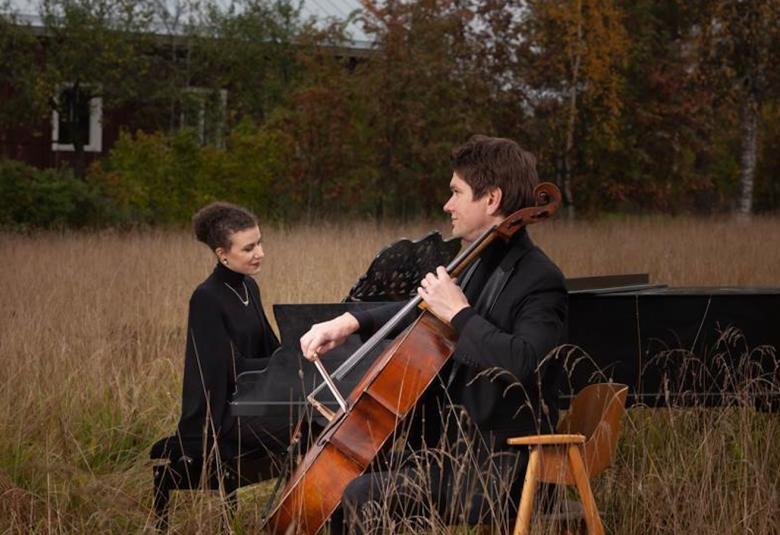 Kuvassa on Nazig Azezian ja Jussi Makkonen flyygelin ja sellon kanssa heinäniityllä soittamassa.