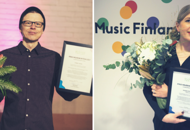 Kuvassa on oikealla Jyrki Laiho onnittelukukat ja kunniakirja käsissään ja oikealla Kaisa Rönkkö kukkineen ja kunniakirjoineen.