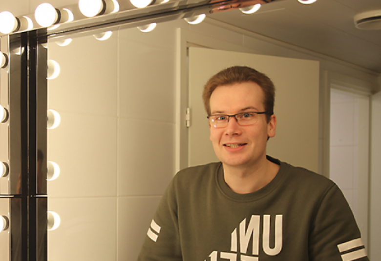 Kuvassa on Janne Rintalan puolivartalokuva ja kuva on otettu peilin kautta.  Kuvan sävy on kellertävä.