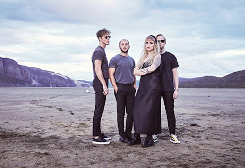 Kuvassa on HalooHelsinki! seisomassa hiekkaisella aukealla, jonka takaosassa on kalliota.