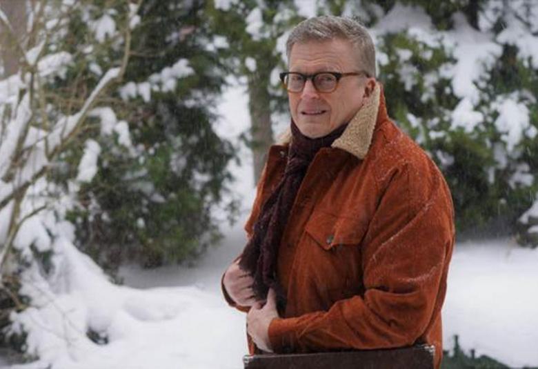 Kuvassa on Mikko Harjunpää lumisessa metsässä ruskeassa kelsiturkissa.