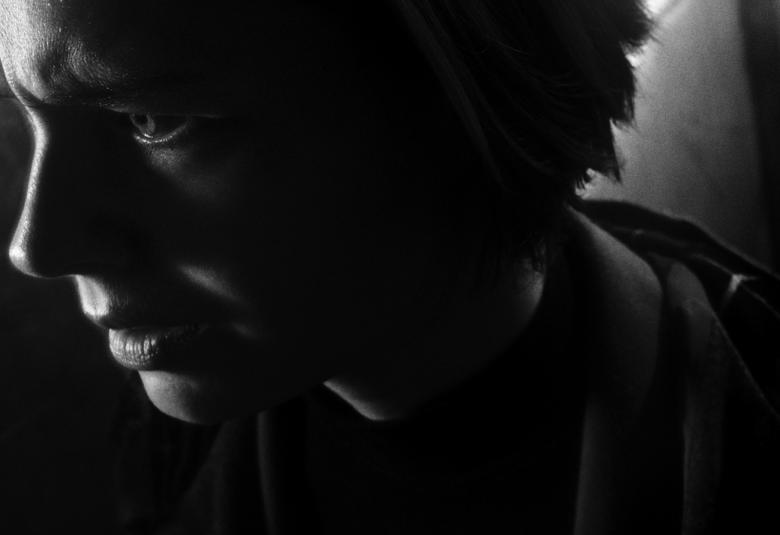 Kuvassa on nuoren naisen kasvot sivuttain vasemmalle ja kasvot alaspäin.  Kuva on musta-valkoinen.