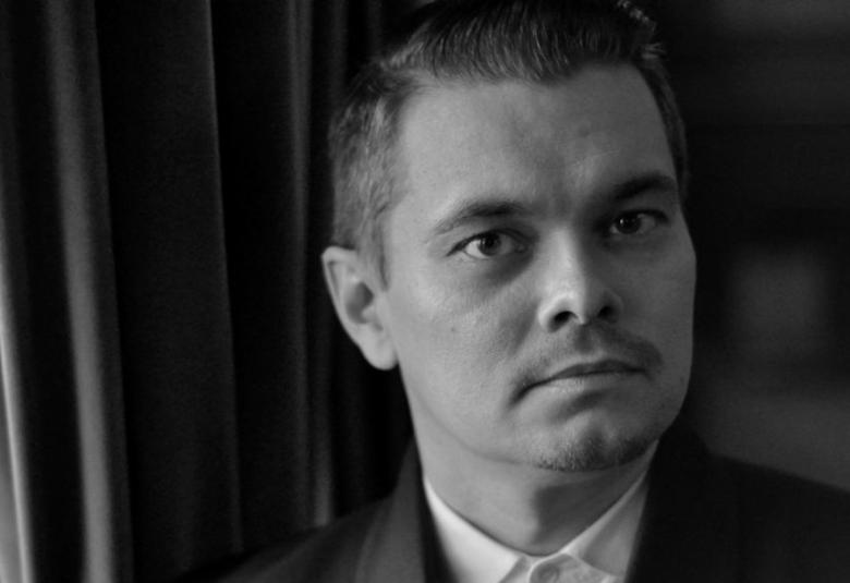 Kuvassa on kasvokuva Tuomas Katajalasta, jolla on lyhyet tummat hiukset.  Kuva on musta-valkoinen.