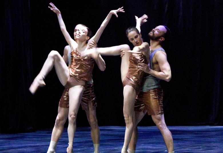 Kuvassa on Dresden Frankfurt Dance Companyn tanssijat pronssin värisissä asuissa, jotka jättävät hihat ja jalat paljaiksi.  Tanssijoissa on kaksi naista ja kaksi miestä.  