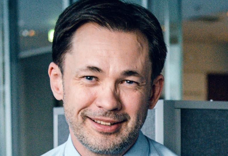 Kuvassa on John Websterin kasvokuva. Hänellä on lyhyet tummat hiukset.