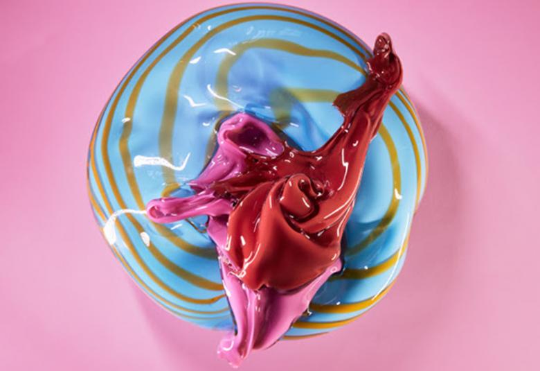 Kuvassa on teos Eggs, jossa on keskellä pinkkiä väriä ja ympärillä on turkoosia ja ruskeita raitoja.  Teos on lasia ja pyöreähkö muodoltaan.