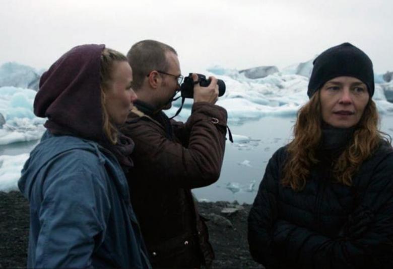 Henna ja Lauri Tanskanen kiikaroimassa islantilaista maisemaa yhdessä ja Elin Petersdottir katsoo oikeassa alakulmassa poispäin.