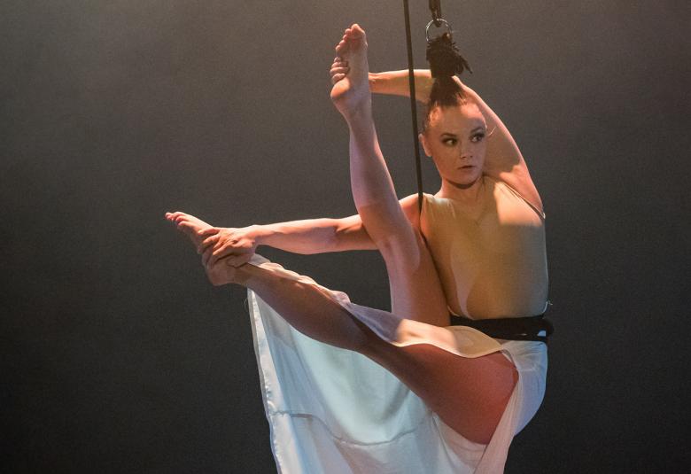 Kuvassa on Enni Kastari kiinni hiuksistaan ja jalat ojennettuina vaakatasossa.