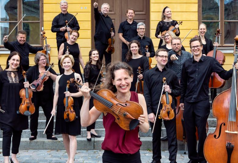 Kuvassa on Keski-Pohjanmaan Kamariorkesteri Vaasan kaupungintalon edustalla ja edessä Malin Broman.