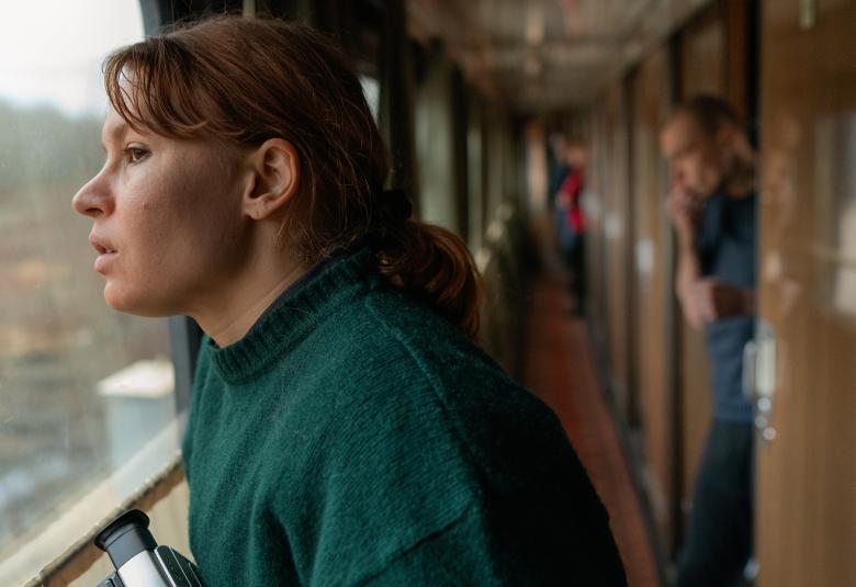 Seidi Haarla katsoo junan ikkunasta ulos ja taustalla näkyy junan käytävää.