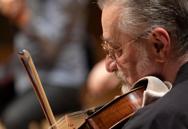 Kuvassa on Vladimir Mendelssohn soittamassa viulua. Kuva on lähikuva takaviistosta.