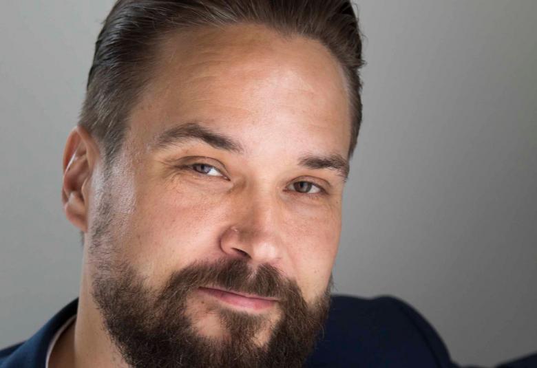 Kuvassa on kasvokuva Jukka Viikilästä, jolla on partaa.