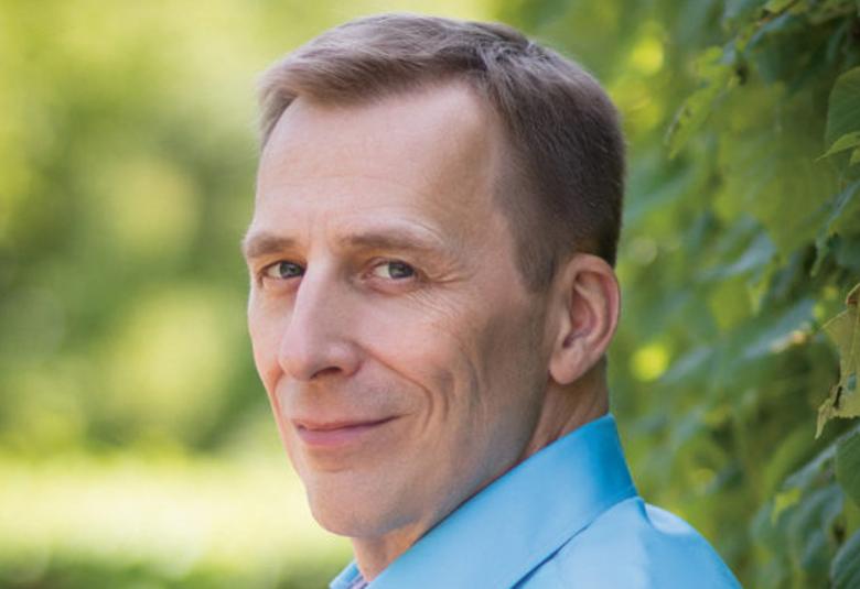 Kuvassa on Osmo Tapio Räihälä taustalla vihreää.