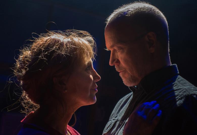 Kuvassa ovat Merja Larivaara vasemmalla ja Kari Heiskanen oikealla. He ovat kasvot vastakkain tummalla taustalla.