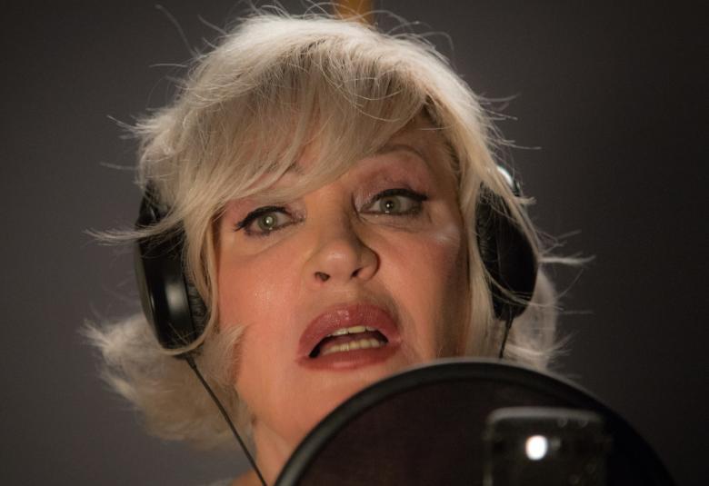 Kuvassa on Hannele Laurin kasvot kuulokkeet päässä laulamassa.