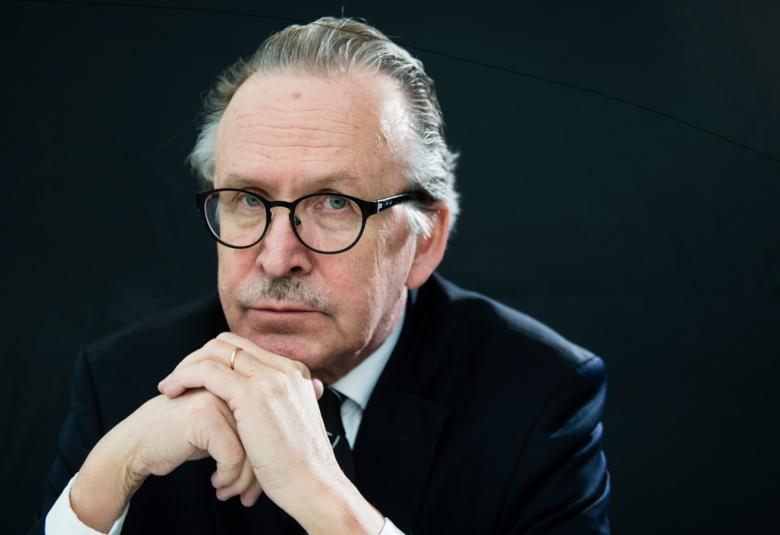 Kuvassa on vasemmalla Alpo Rusi istumassa vasemman suuntaisesti ja pitää käsiää leukansa alla. 