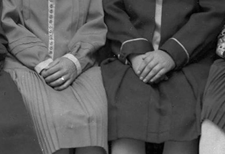 Kuvassa on istuvia naisia ja kuvassa näkyy vain heidän vaatteensa ja käsiä eikä jalkoja.  Kuva on musta-valkoinen.