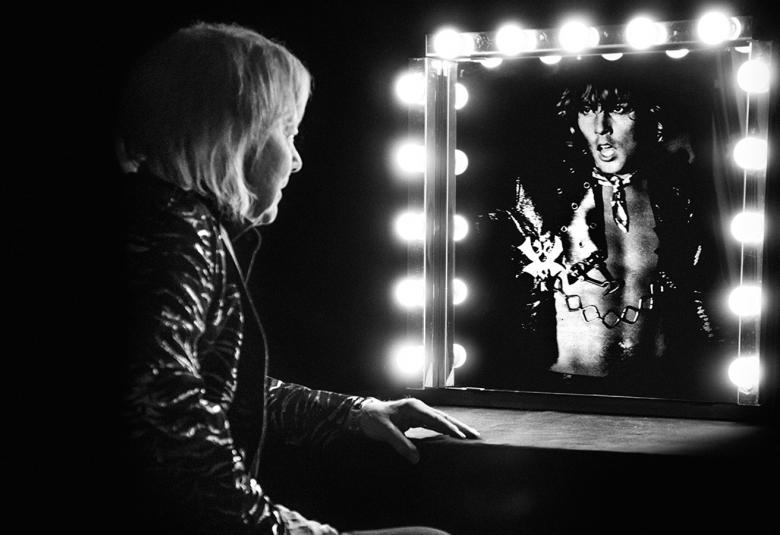 Kuvassa on Danny istumassa puoliksi selin ja hän katsoo lamppujen ympäröimää peiliä, josta näkyy nuoren Dannyn kasvot. Tila on pimeä.