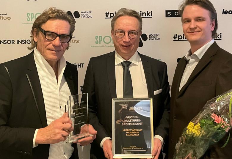 Kuvassa ovat tummissa puvuissa vasemmalta Tuomas Hoikkala, Jukka Ollikainen ja Alvar Huhtanen.  Heillä on kädessään palkinnot ja kukkia.