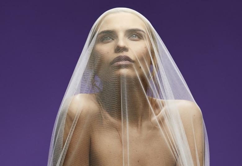 Kuvassa on Sara Jakubiak puolivartalokuvassa ja katse kohotettuna ylöspäin vaalea huntu päässään.