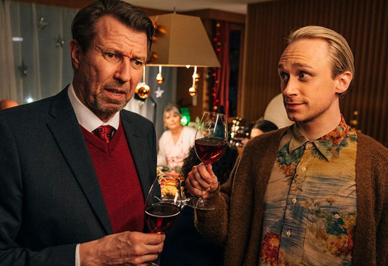 Kuvassa ovat Martti Suosalo ja Christoffer Strandberg puolivartalokuvassa seisomassa ravintolassa viinilasit kädessään.