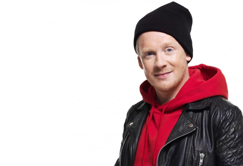 Kuvassa on Redrama mustassa nahkatakissa ja pipo päässään.