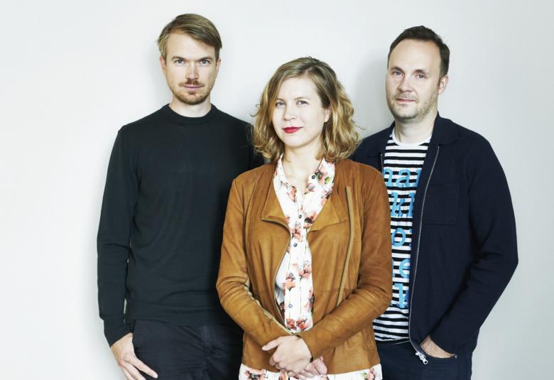 Kuvassa ovat Johannes Koponen, Minea Koskinen ja Jussi Pullinen rennoissa vaatteissa puolivartalokuvassa.