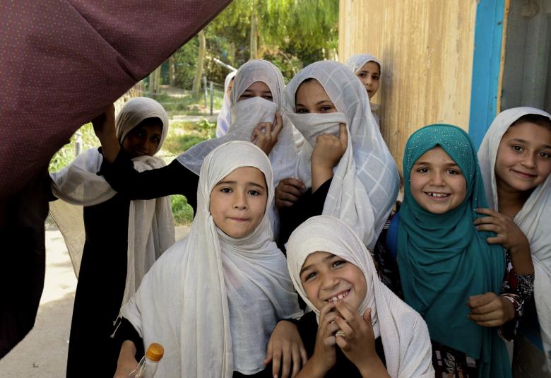 Kuvassa on kahdeksan tyttöä Afganista ja heillä on valkoiset huivit päässään.  Tyttöjen ilmeet ovat iloisia.