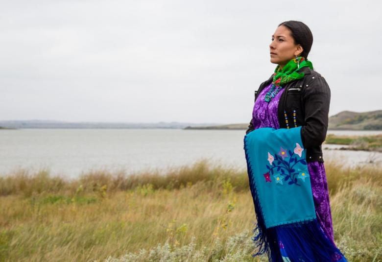 Kuvassa on Floris seisomassa avoimessa maisemassa ruohikossa järven rannalla katsomassa etäisyyteen.