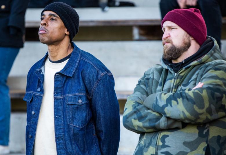 Kuvassa vasemmalla on Pete Santos ja oikealla Paleface. Molemmat ovat ulkokatsomossa ja ovat pusakat päällä.  Heidän katseensa on vasemmalle.