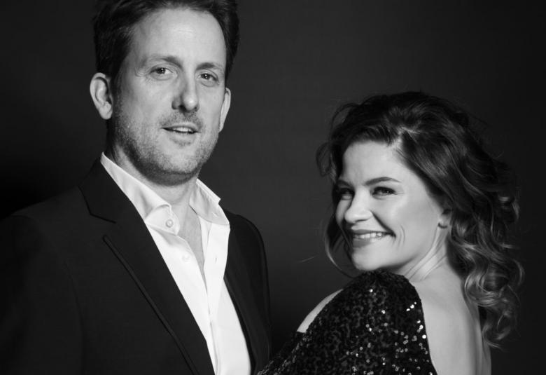 Kuvassa ovat Marjukka Tepponen ja Kevin Greenlaw musta-valkoisessa kuvassa.  He istuvat siten, että Greenlaw on vasemmalla ylempän ja Tepponen alempana.