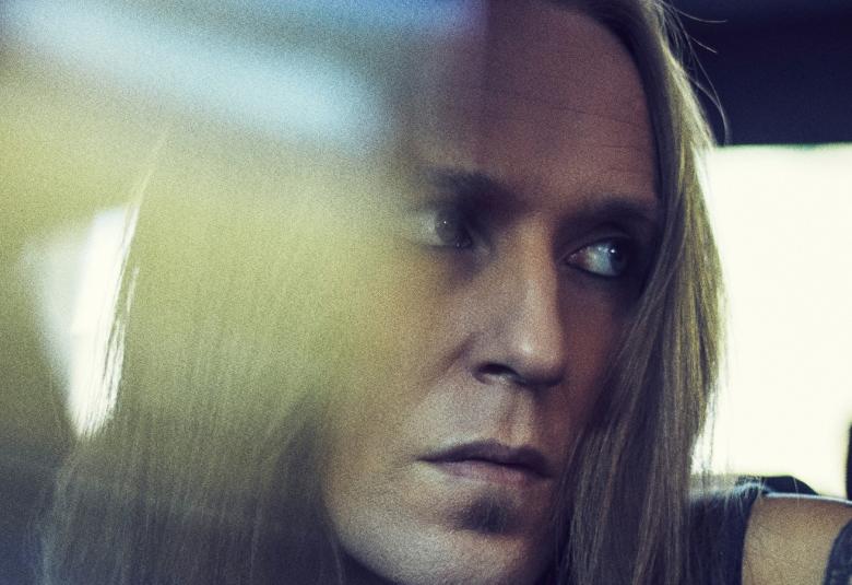 Kuvassa on Alex Laihon kasvot katse oikealle. Vasemmalla on vihertävä heijastus.