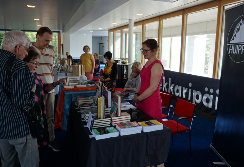 Kuvassa on Dekkaripäivien myyntipöytiä ja yleisöä katsomassa.