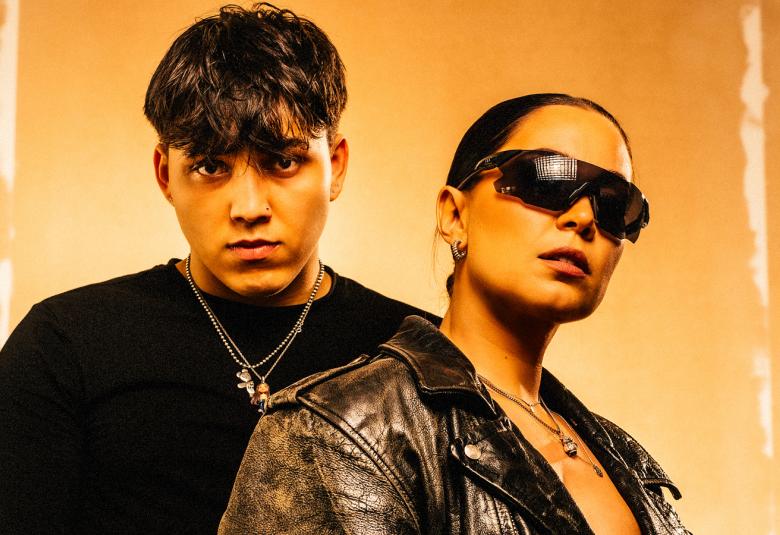 Kuvassa ovat Anna Abreu mustassa nahkatakissa ja aurinkolaseissa ja hänen takanaan on Averagekidluke mustassa t-paidassa. Kuva on puolivartalokuva ja tausta on kellertävä.