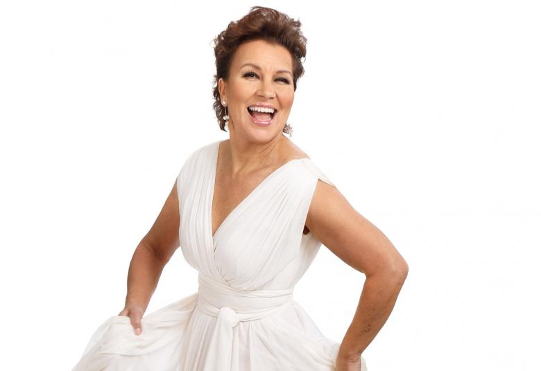 Kuvassa on Arja Koriseva valkoisessa puvussa puolivartalokuvassa.