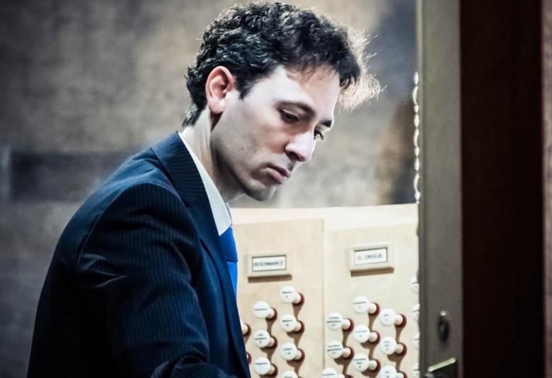 Kuvassa on Vincent Dubois soittamassa urkuja.  Kuva on sivukuva.