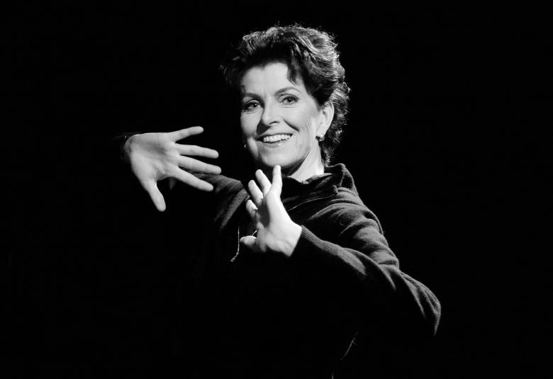 Kuvassa on Tiina Lindfors puolivartalokuvassa kämmenet edessä vinottain.