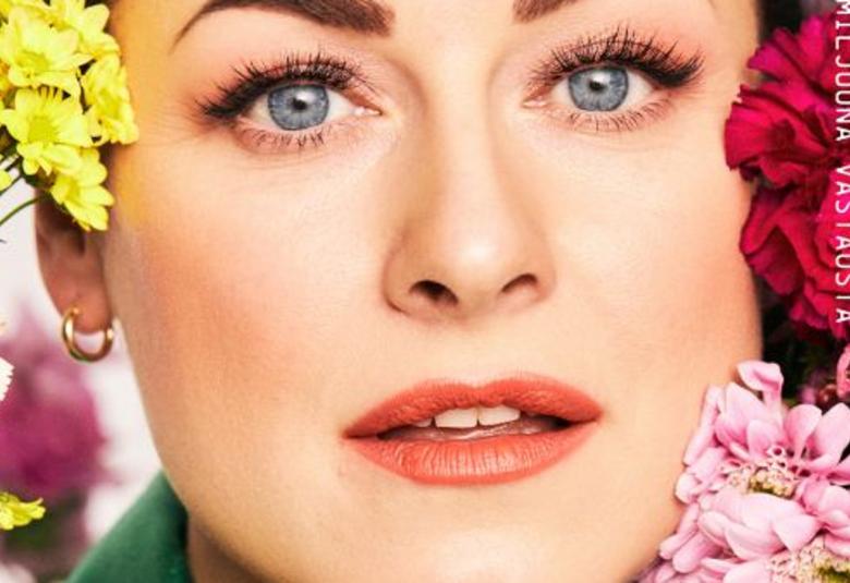 Kuvassa on Erinin kasvot ja ympärillä kukkia.  Isoilla kirjaimilla lukee Erin. 