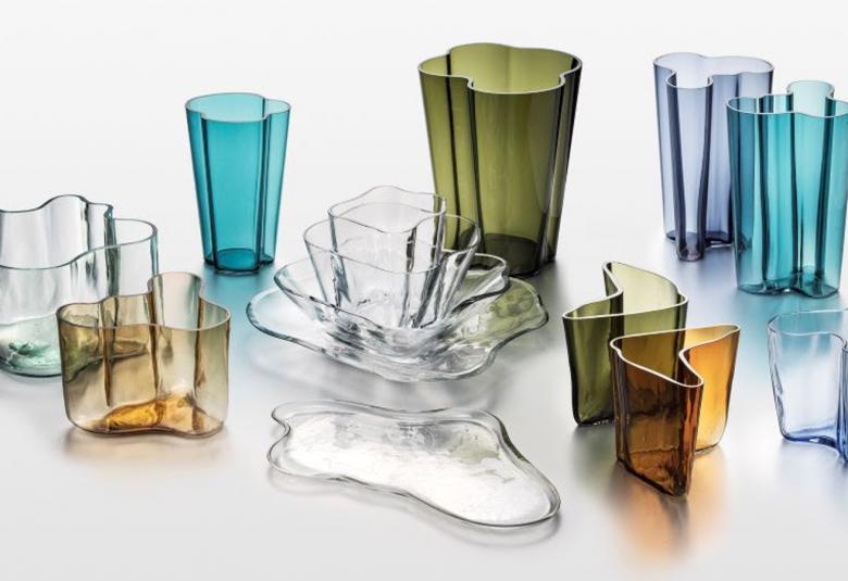 Kuvassa on  Iittalan Alvar Aalto -kokoelman erivärisiä lasiesineitä kuten maljakoita ja maljoja.
