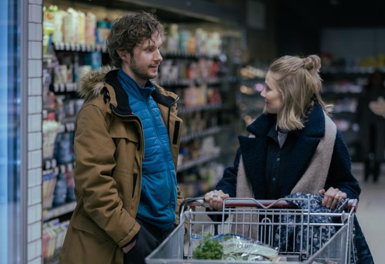 Kuvassa ovat Paavo Heikki Ranta ja Inari Tola keskustelevat ruokakaupassa.  Tolalla on ostoskärryt edessään.