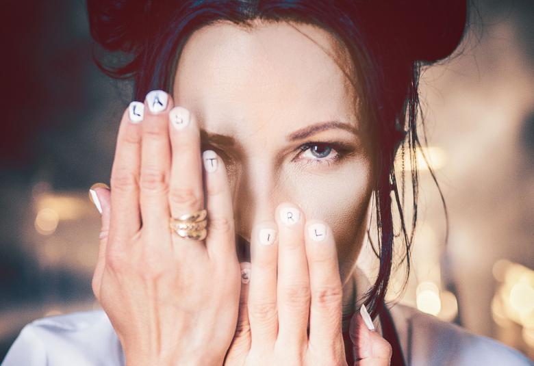 Kuvassa on Erja Lyytisen kasvot ja hänellä on kädet kasvojen edessä.