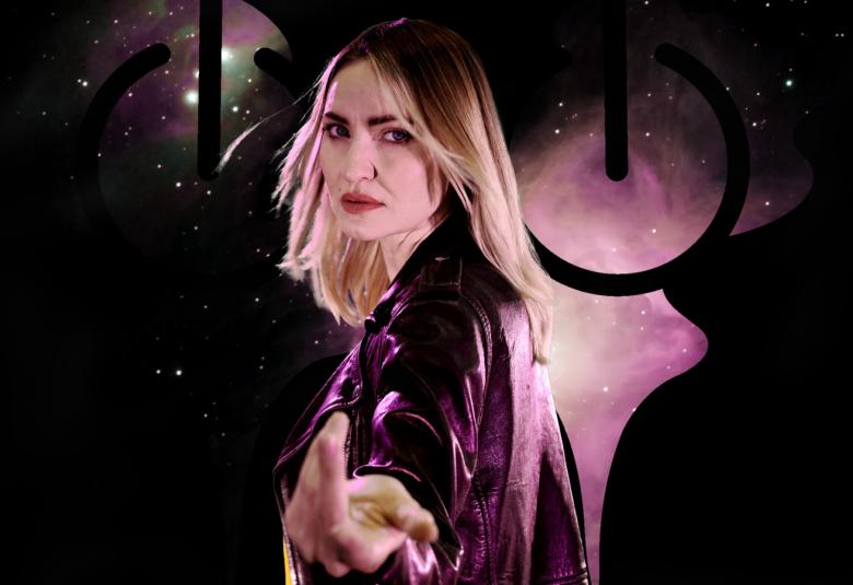 Kuvassa on keskellä kääntyneenä sivuttain vaalea näyttelijätär, joka ojentaa kättään eteenpäin.  Tausta on tumma.